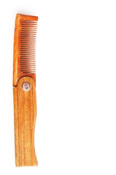 Folding wooden comb on a white background. Close up.