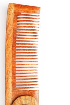 Folding wooden comb on a white background. Close up.
