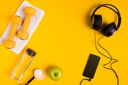 Athlete's set with female clothing, dumbbells and bottle of water on yellow background. Top view. Still life
