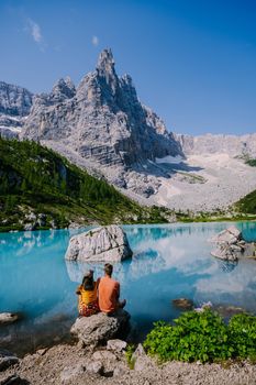 Lake Sorapis Italian Dolomites, Morning with clear sky on Lago di Sorapis in Italian Dolomites, lake with unique turquoise color water in Belluno province in Nothern Italy. couple in the mountains