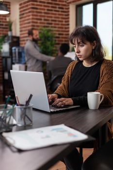 Entrepreneur woman analyzing company statistics typing marketing strategy on laptop computer working in startup office. Executive manager brainstorming ideas planning business collaboration