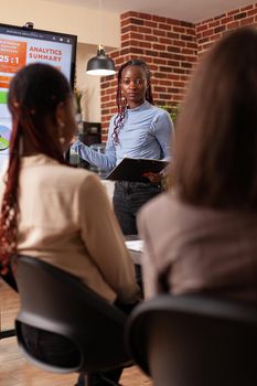 Diverse businesspeople analyzing marketing graph on monitor working at company strategy during business meeting in startup office. Executives managers brainstorming ideas for financial project