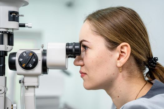 Optometrist examining the eyes of a male patient in a modern ophthalmology clinic. Eye doctor with man patient during an examination in modern clinic. Optometry concept. Eyesight exam in clinic.