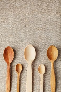 Wooden spoons made of natural wood on burlap fabric as a craft. Natural natural materials. Caring for the environment