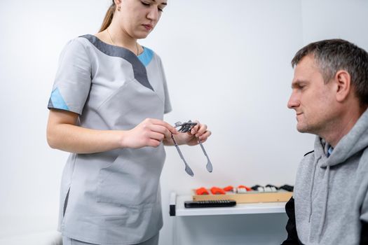 Examining patient vision. Eye exam. Optometrist checking patient eyesight and vision correction. Patient undergoing vision check with special ophthalmic glasses at eye clinic. Selection of eyeglasses.