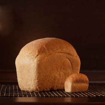 big and small loaf of bread laying on the table on black background