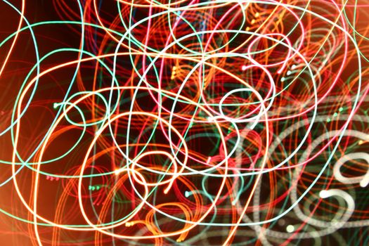 abstract color swirl garland lights. Blurred glowing on dark background