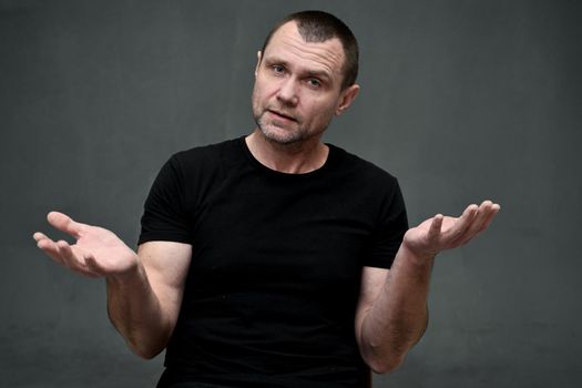 Portrait of an adult man talking directly to the camera on a gray background