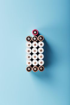AA batteries are arranged in the form of a large battery on a blue background. Top view. The concept of energy supply and utilization