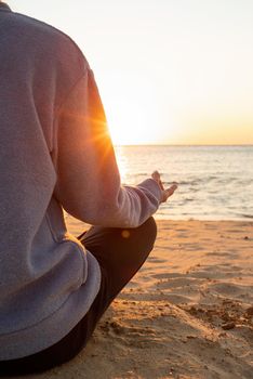 Health and wellness. Young healthy woman practicing yoga on the beach at sunset