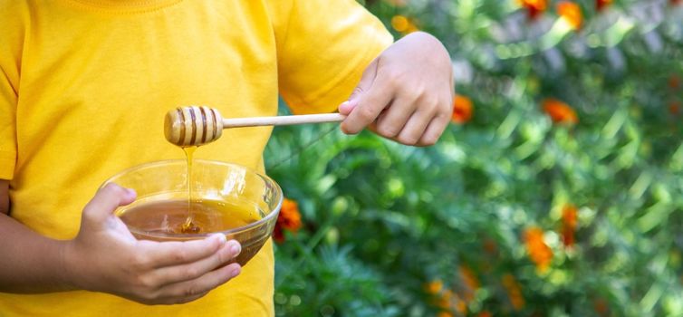 child eats honey in the garden. Nature. selective focus