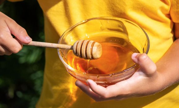 child eats honey in the garden. Nature. selective focus