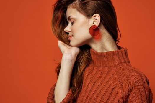 woman wearing red sweater earrings jewelry posing close-up. High quality photo