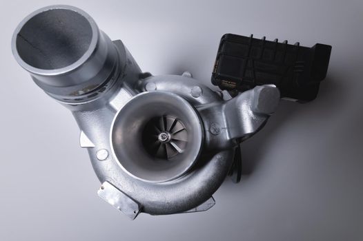 New car turbine on a gray background. Blower for air intake system.