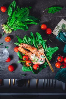 A plate with fresh green raw spinach and fried wild salmon, tomatoes and cream cheese sauce High quality photo