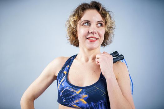 Fit woman with jump rope posing in the gym. Sport exercises healthy lifestyle concept. Sporty happy woman with skipping rope posing to the camera. Active lifestyle concept. Healthy lifestyle.