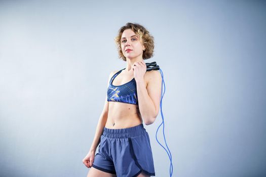 Smiling sportswoman posing with a skipping rope. Female with muscular body posing with jump rope. Fitness model. Body positivity, sport, fitness concept. Healthy lifestyle. Fit woman with jump rope.