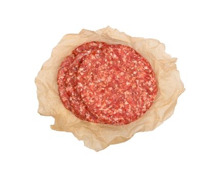 Three fresh raw beef meat burgers for hamburger wrapped in brown paper parchment isolated on white background, elevated top view, directly above