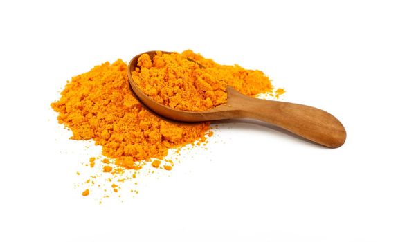 Close up one wooden scoop spoon full of yellow turmeric spice powder spilled and spread around isolated on white background, high angle view