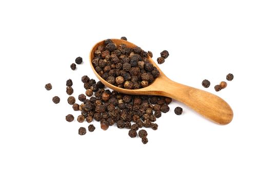 Close up one wooden scoop spoon full of black pepper peppercorns and heap of peppercorns spilled and spread around isolated on white background, high angle view