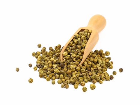 Close up one wooden scoop full of green pepper peppercorns and heap of peppercorns spilled and spread around isolated on white background, high angle view