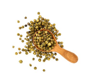 Close up one wooden scoop spoon full of green pepper peppercorns and heap of peppercorns spilled and spread around isolated on white background, elevated top view, directly above