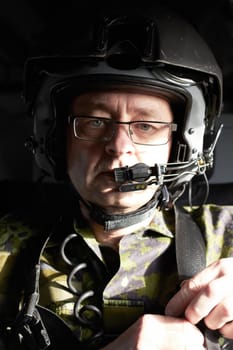 Portrait of a pilot in his aircraft wearing a helmet with a communication device