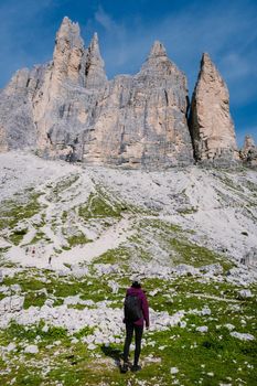 Tre Cime di Lavaredo peaks or Drei Zinnen at sunset, Dobbiaco Toblach, Trentino -Alto Adige or South Tyrol, Italy. Europe Alps. Asian woman hiking in the mountains