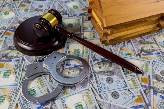 Concept for court, bankruptcy, taxes, mortgage the court imposed an arrest to the house with Judge hammer US dollars banknotes handcuffs