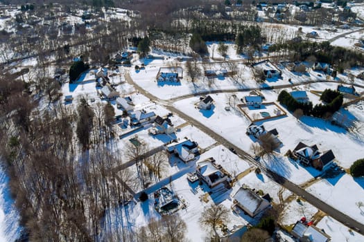 Aerial view of landscape top of the winter town residential houses with snow on covered houses and roads.