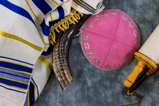 Jewish holidays, during prayer items kippa with prayer shawl tallit on shofar, torah scroll in a synagogue