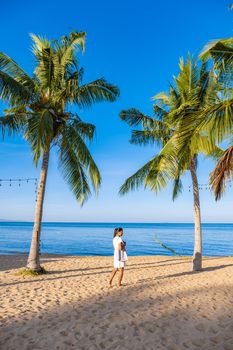 Na Jomtien Beach Pattaya Thailand, white tropical beach during sunset in Pattaya Najomtien. Asian woman walking at the beach with palm trees, tropical beach