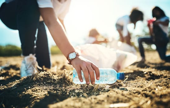 Shot of an unrecognisable teenager picking up litter off a field at summer camp