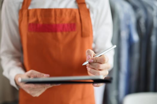 Tablet with stylus in female hands in uniform. Receiving and issuing order concept