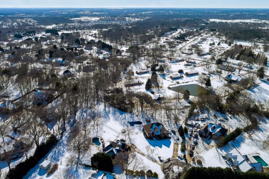Aerial view of snowed in traditional housing estate in the suburbs in dangerous weather conditions