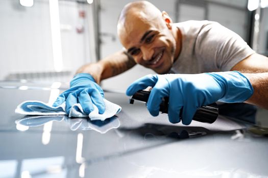 African American man car service worker applying nano coating on a car, close up