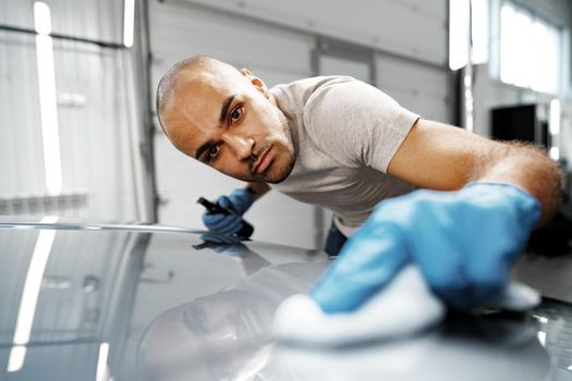 African American man car service worker applying nano coating on a car, close up