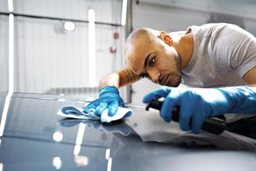 African American man car service worker applying nano coating on a car, close up