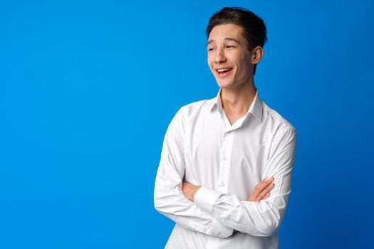 Portrait of a smiling teen boy against blue background, close up