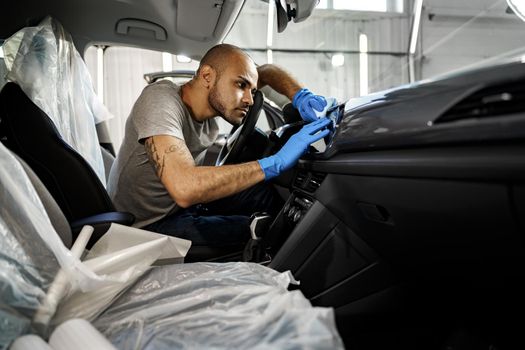 A man cleaning car interior, car detailing in Carwash service, close up