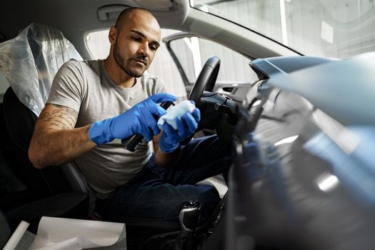 A man cleaning car interior, car detailing in Carwash service, close up