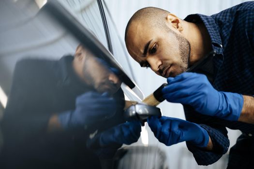 African American man car service worker applying nano coating on a car, close up