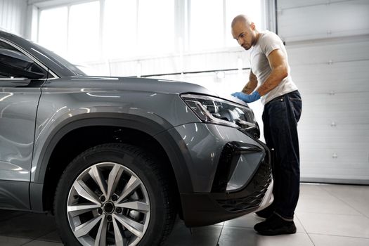 African American man car service worker applying nano coating on a car, close up