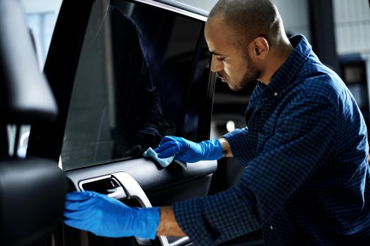 African American man car service worker applying nano coating on a car, close up