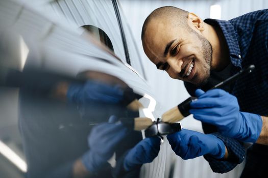African American man car service worker applying nano coating on a car, close up
