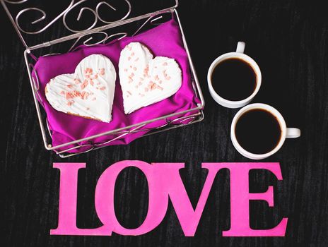 two cups of coffee, cookies in the form of heart inscription love close-up. valentine card