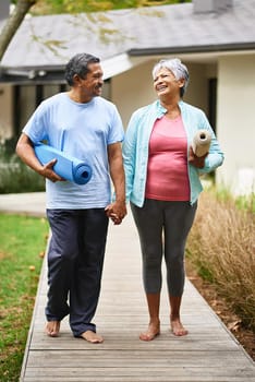 Shot of a happy older couple carrying their exercise mats outdoors