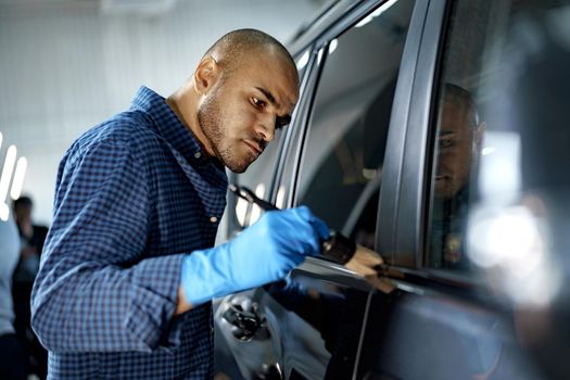African American man car service worker applying nano coating on a car, close up