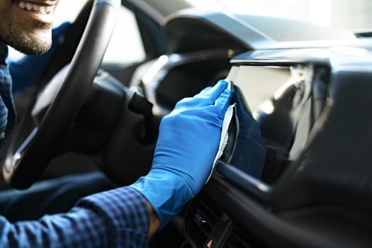 A man cleaning car interior, car detailing in Carwash service, close up
