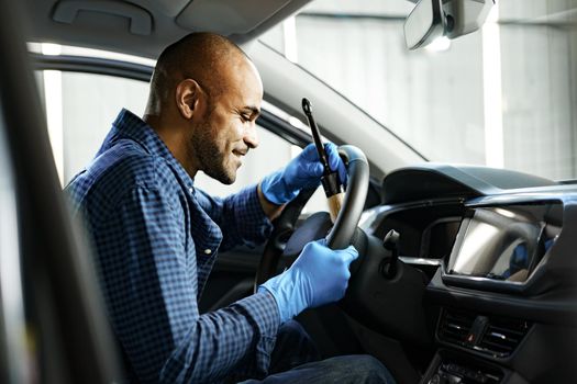 A man cleaning car interior, car detailing in Carwash service, close up